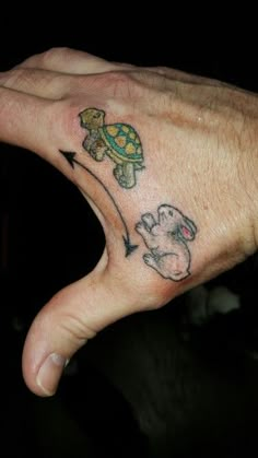 a person's hand with a small turtle on it and an arrow in the middle