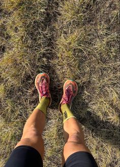 a person standing in the grass with their feet crossed