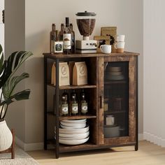 a wooden cabinet with plates and cups on it next to a potted plant in a living room