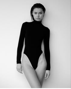 a black and white photo of a woman in a bodysuit