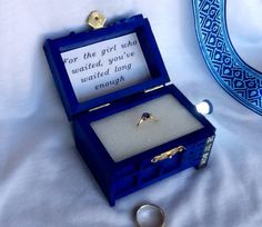 an open blue box with a ring in it on a white sheet and the words i want to be proposed to like this school of magic