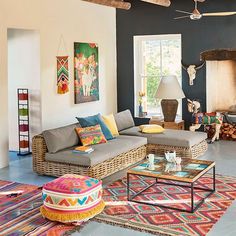 a living room filled with lots of furniture next to a large painting on the wall