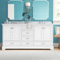 a bathroom with blue walls and two sinks in front of the mirror on the wall