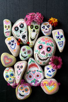 a pile of colorful skulls with flowers in the middle