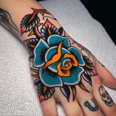 a person's hand with tattoos on it and a flower tattoo on the wrist