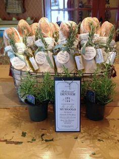 a basket filled with lots of flowers sitting on top of a wooden table next to a sign