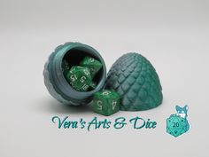 two green dices sitting in a container with the words vein's arts & dice