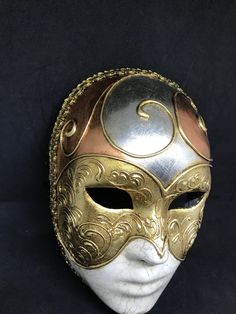 "Size: one size Traditional and original papier-mache Venetian mask, handmade and decorated with three leaf,gold,silver and bronze, cracked technique, stucco and acrylics. This traditional Venetian mask shape is called \"Volto mask\" and is a full face mask. All our masks are handmade papier-machè masks, made in Venice. Our decorators use techniques typical of the Venetian tradition such as stucco, acrylics, gold and silver-leaf, macramè, passementerie, pearls and crequelè to give you a wide ran Traditional Gold Masks And Prosthetics For Carnival, Traditional Gold Costume Masks And Prosthetics, Traditional Gold Masks And Prosthetics For Costume, Gold Artistic Mask For Carnival, Artistic Gold Mask For Carnival, Artistic Gold Masks And Prosthetics For Festivals, Gold Full Face Masks For Carnival, Artistic Gold Masks And Prosthetics For Costume, Gold Full Face Masks And Prosthetics For Carnival