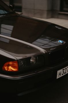 a black bmw parked on the street next to a building