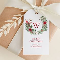 a christmas gift wrapped in brown paper with a white ribbon and monogramming on it