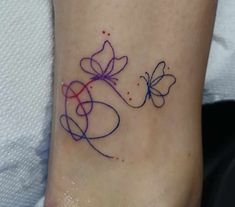 a small tattoo on the ankle of a woman's foot with two butterflies flying over it