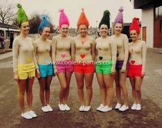 a group of young women standing next to each other in bathing suits and hats on their heads