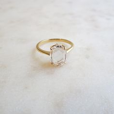 a white diamond ring sitting on top of a table