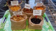 four bags filled with different types of snacks on top of a green and white tray