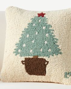 a decorative pillow with a potted christmas tree on it