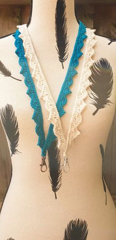 a mannequin with blue and white crocheted feathers on it's neck