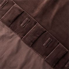 the back side of a brown jacket with buttons and stitching on it's sides