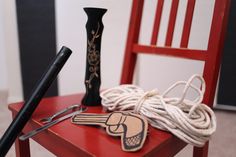 a red chair with some items on top of it and a black vase next to it