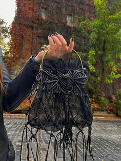 a woman is holding up her purse on the street