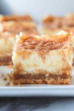 two pieces of cheesecake sitting on top of a white plate with cinnamon crumbs