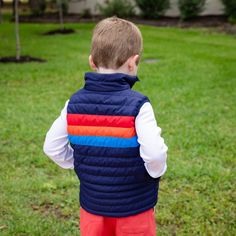 Navy puffer vest with color block stitching is a great basic and versatile style. Includes matching zipper and front pockets. Fully lined and runs true to size. Model is wearing size 4. Pairs perfectly with our Thomas Pants in Sheffield Red and True Blue. Machine-washable. Sporty Puffer Vest For Outdoor Activities, Sporty Sleeveless Puffer Vest, Blue Sporty Sleeveless Outerwear, Sporty Sleeveless Blue Outerwear, Sleeveless Quilted Vest For Outdoor Activities, Outdoor Activities Vest With Zipper Closure, Casual Nylon Vest With Zipper Closure, Sleeveless Vest With Zipper For Outdoor Activities, Sleeveless Outerwear With Zipper For Outdoor Activities