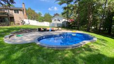 a backyard with a swimming pool surrounded by green grass