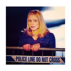 a woman is standing behind a police line sign with her hands on the railing and looking at the camera