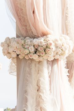 a woman wearing a wedding dress with flowers on her belt and veil over her head