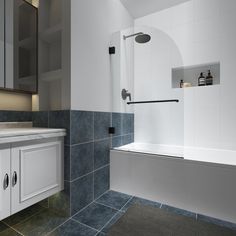 a bathroom with gray tile and white cabinets