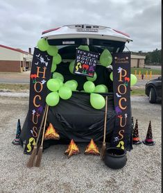 the back of a car decorated with balloons and brooms