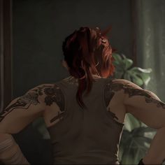 a woman with red hair and tattoos on her back