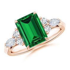 an emerald and diamond ring with three diamonds on the band, set in 18k rose gold