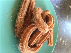 several churros are on a blue plate with powdered sugar