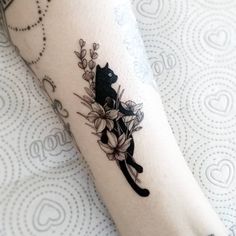 a black cat sitting on top of a flowery branch tattoo design with flowers around it