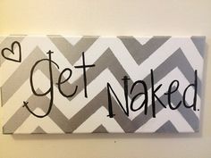 a painted sign that says get naked on the side of a white and gray wall