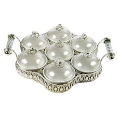 a silver tray with twelve white glass balls on the bottom and two rows of metal handles