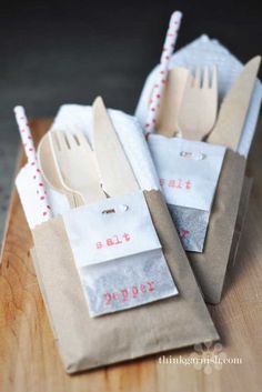 some paper bags with forks and spoons in them