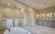 a large bathroom with two sinks and a bathtub next to a walk in shower