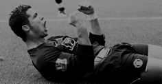 a soccer player laying on the ground with his arms in the air