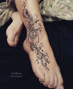 a woman's foot with a tattoo design on her left leg and an arrow in the middle