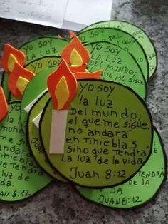 four pieces of paper that have candles on top of them, with words written in different languages