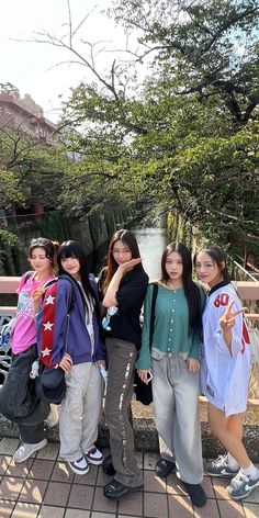 four girls posing for the camera with trees in the background