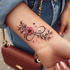 a woman's foot with a tattoo on it that has flowers and hearts in the middle