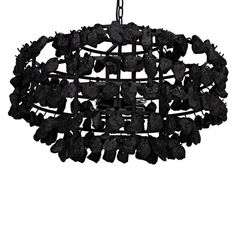 a black chandelier hanging from a chain with rocks on it and leaves in the middle