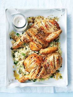 chicken and rice on a white plate with a jar of ranch dressing next to it