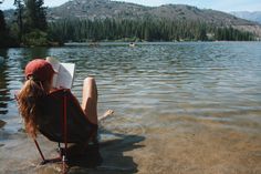 a woman sitting in the water reading a book