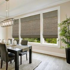 a dining room table and chairs with blinds on the windows