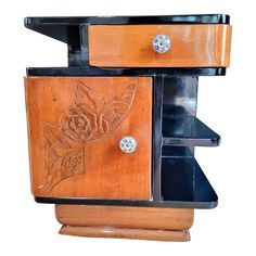 a wooden cabinet with metal knobs and flowers on the front, against a white background