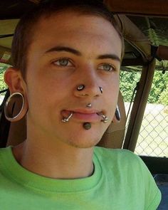 a woman with piercings on her nose and nose ring in front of her face