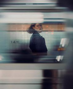 a blurry photo of a woman standing in front of a train